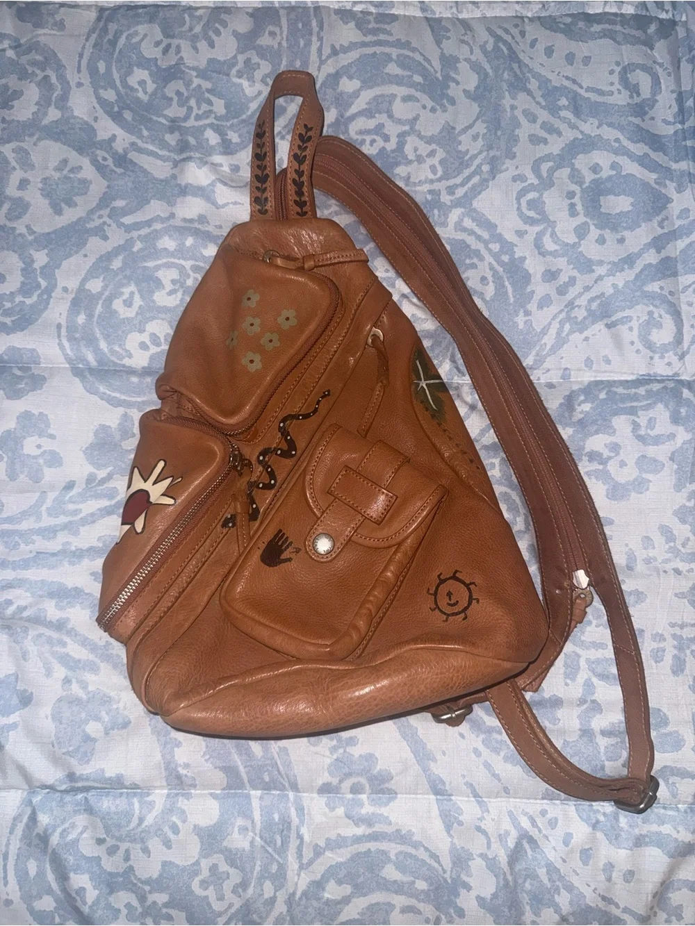 Compact Brown Leather Sling Backpack with Decorative Accents